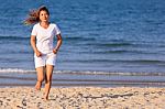 Asian Woman Running On Beach Stock Photo
