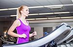 Attractive Young Woman Running On A Treadmill, Exercise At The F Stock Photo