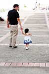 Baby Walking With Her Father Stock Photo