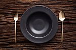 Black Bowl Plate Fork Spoon On Wooden Table Background Stock Photo
