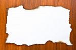 Burned Paper On Wooden Backdrop Stock Photo