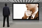 Businessman Standing Looking At The Tv Screen Stock Photo
