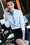 Cheerful Businesswoman Talking On Phone Standing In Her Office Stock Photo