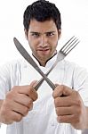Chef Holding Crossed Fork And Knife Stock Photo