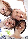 Circle Of Happy Friends With Their Heads Together Stock Photo