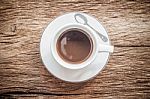 Close Up Overhead View Of A Cup Of Espresso Coffee On A Old Wooden Background. Vintage Style Stock Photo