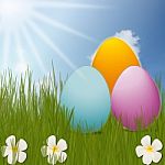 Colorful Easter Eggs Sitting On Grass Field With Blue Sky Background