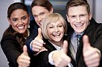 Corporate Team Gesturing Thumbs Up Stock Photo