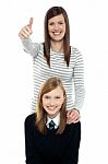 Cute Schoolgirl With Her Mom. Mother Gesturing Thumbs Up Stock Photo
