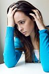 Depressed Young Woman Sitting At Home Stock Photo