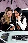 Executive Busy On Phone Call And Her Employee Holding Umbrella Stock Photo