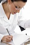 Female Doctor Writing on clipboard Stock Photo