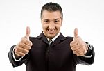 Front View Of Smiling Boss Showing Thumb Up With Both Hands Stock Photo