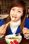 Girl Eating Meatball With Shopstick And Spoon Stock Photo