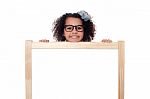 Girl Peeping From Behind White Writing Board Stock Photo
