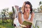 Girl Reading Book Outdoors Stock Photo
