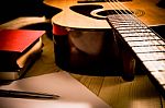 Guitar With Red Book And Pen On A Wooden Table, Vintage Style Stock Photo