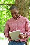 Happy Middle Aged Man Using Tablet In Park Stock Photo