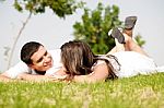 Happy Young Couple Lie Down On Grass Stock Photo