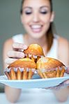 Happy Young Woman Eating Delicious Muffins Stock Photo