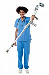 Lady Doctor Handing Over Crutches To The Patient Stock Photo