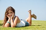 Little Girl lying with cupping face Stock Photo