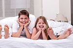 Loving Brother And Sister Lying And Having Fun On The Bed Stock Photo