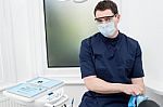 Male Dentist With Tools At Dental Office Stock Photo