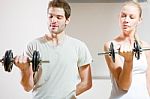 Man And Woman Lifting Dumbbell In Gym Stock Photo