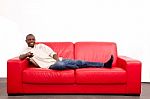 Man On The Sofa With Remote Control Stock Photo
