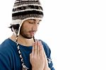 Man Praying with woolen Cap Stock Photo