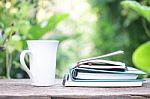 Notebook  And Coffee Cup On Wooden Table Stock Photo