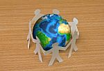 Paper Cut Of People Standing In A Circle Around Globe Stock Photo