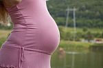 Pregnant Woman standing outdoors Stock Photo