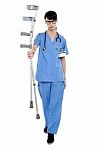 Sad Doctor Holding Up Crutches In Hand Stock Photo