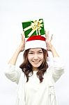 Santa Woman Showing Gift Wearing Santa Hat Stock Photo