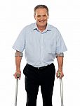 Senior Man Standing With Crutches Stock Photo