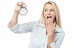 Shocked Woman Holding Alarm Clock Stock Photo