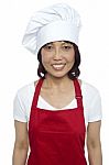 Smiling Lady Chef Wearing Red Apron Stock Photo