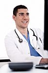 Smiling Young Doctor At His Office Stock Photo