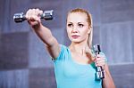 Strong Young Woman Exercising With Dumbbells At The Gym Stock Photo