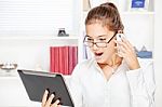Surprised Businesswoman Looking At Tablet Computer Stock Photo