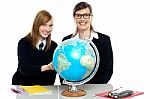 Teacher And Student Viewing Globe In Geography Classroom Stock Photo