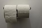 Toilet Paper On Holder On The Wall Stock Photo