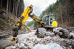 Wheeled Excavator In A River In The Autumn Forest Mountains Stock Photo
