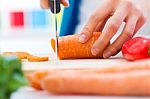 Woman Hand Cutting Carrots In Kitchen Stock Photo