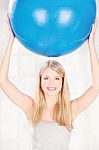 Woman Holding Pilates Ball Over Her Head Stock Photo