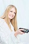 Woman In Bathrobe Holding Remote Controller Stock Photo