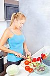 Woman In Kitchen Cutting Vegetables Stock Photo