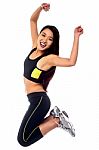Woman In Sportswear Jumping With Joy Stock Photo